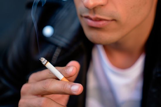 Мужчина курит сигарету